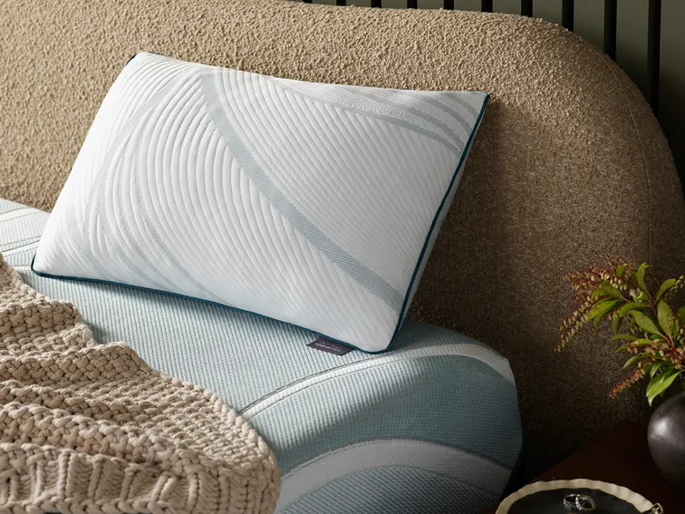 Cooling white pillow with a quilted cover on a made bed